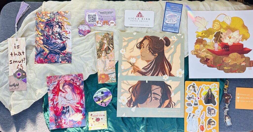 Art and merchandise purchased at Otakon 2025, including art by ginkohs, noino, and frog_well_.